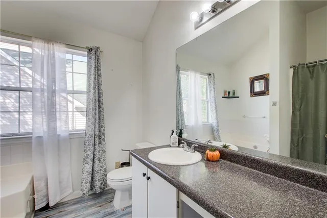 a bathroom with a granite countertop sink toilet and shower