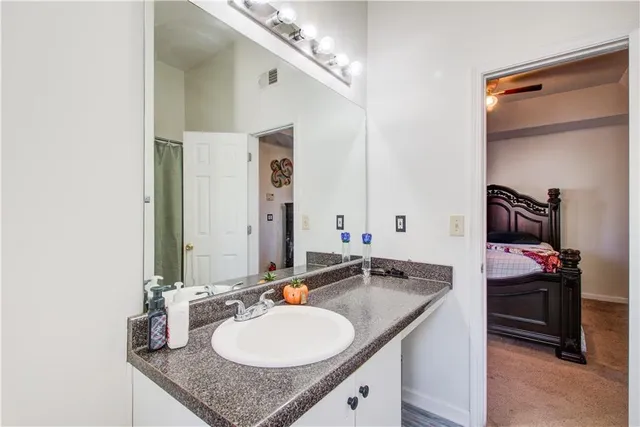 a bathroom with a granite countertop sink and a mirror
