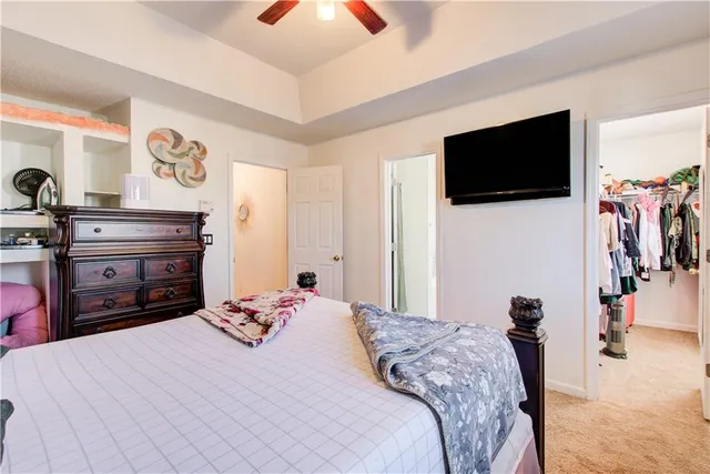 a bedroom with a bed and a flat tv screen on wall