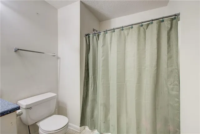 a white toilet sitting next to a shower curtain