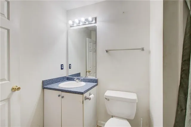 a bathroom with a toilet sink and mirror