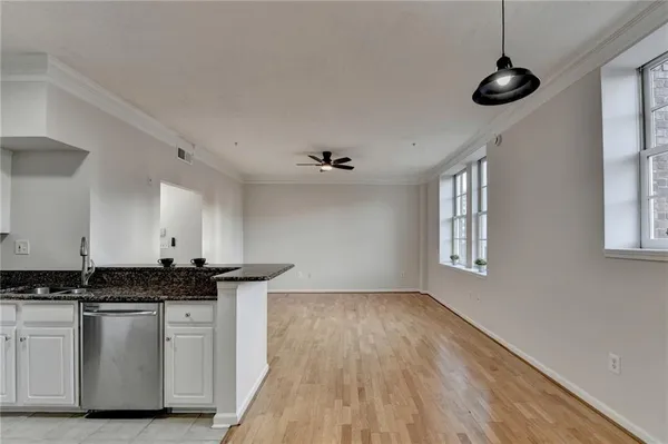 a kitchen with stainless steel appliances granite countertop a sink a stove a refrigerator cabinets and a window