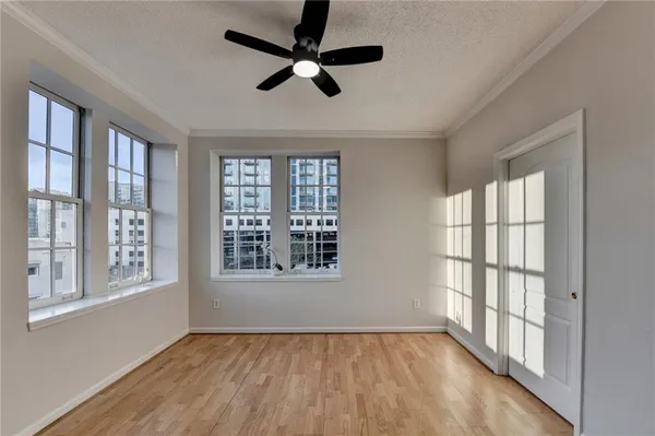 a view of an empty room with a window and wooden floor