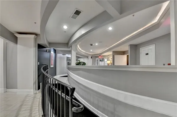 a view of a hallway with wooden floor and staircase