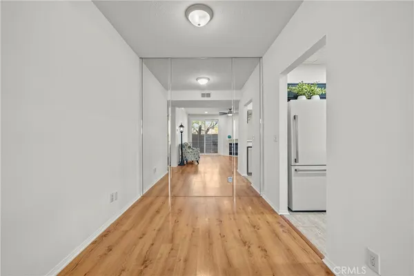 a view of a hallway with wooden floor and closet