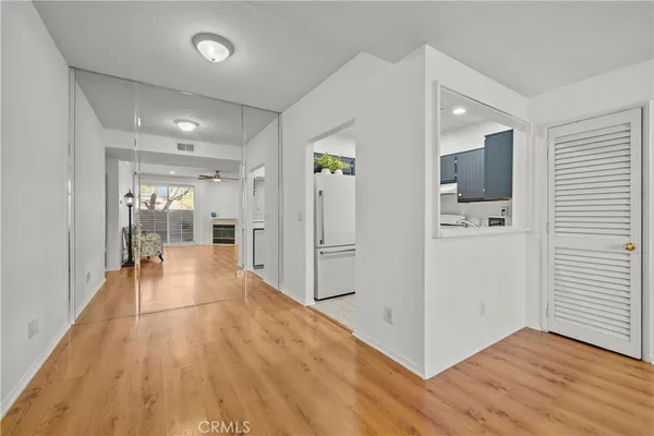 a view of a hallway with wooden floor and closet