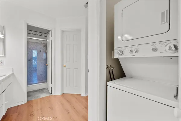 a view of washer and dryer with bathroom in the background