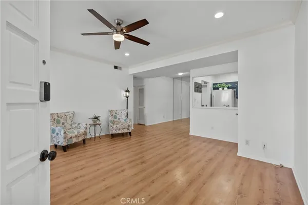 a view of empty room with wooden floor and ceiling fan