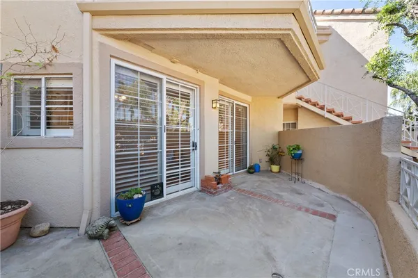 a backyard of a house with potted plants and a bench