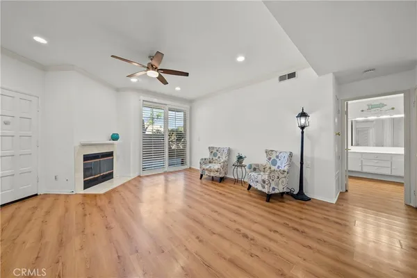 a view of a livingroom with furniture a fireplace wooden floor and chandelier