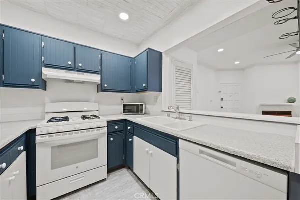 a kitchen with a stove sink and cabinets