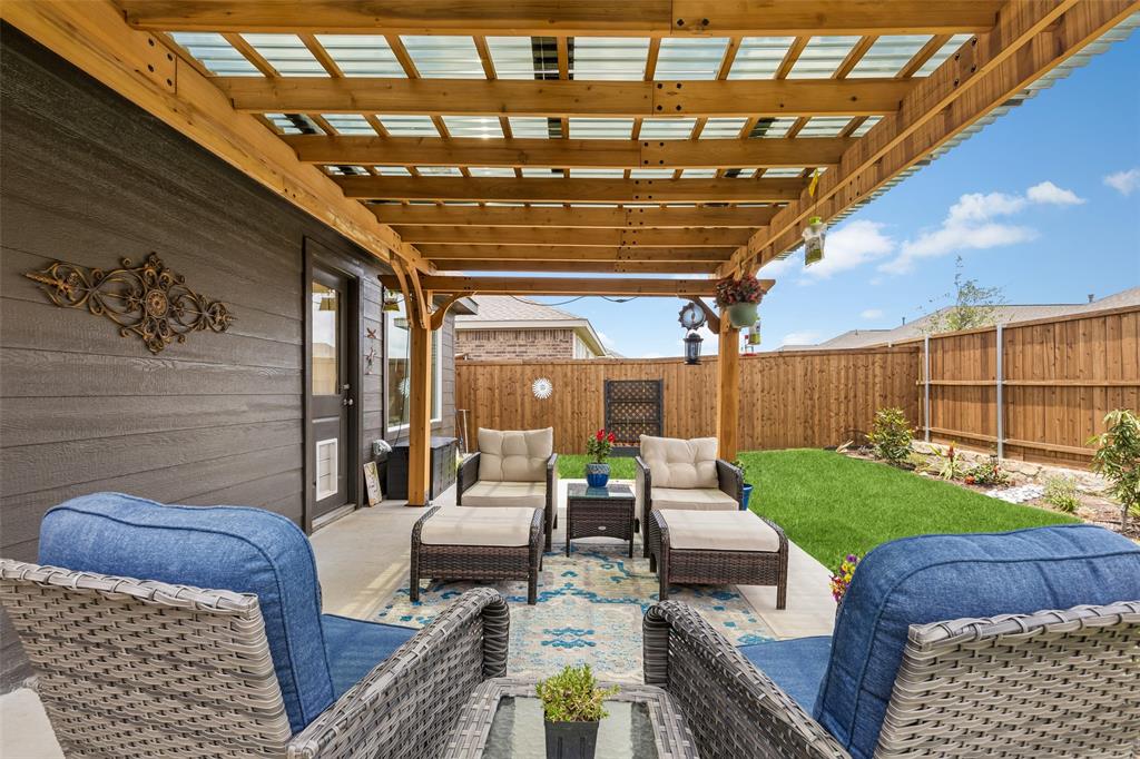 14163 Kempt Drive Pilot Point, TX 76258 - Photo 20 of 29 This charming outdoor living space offers plenty of room for lounging, dining, and entertaining while overlooking the beautifully landscaped, fully fenced backyard.