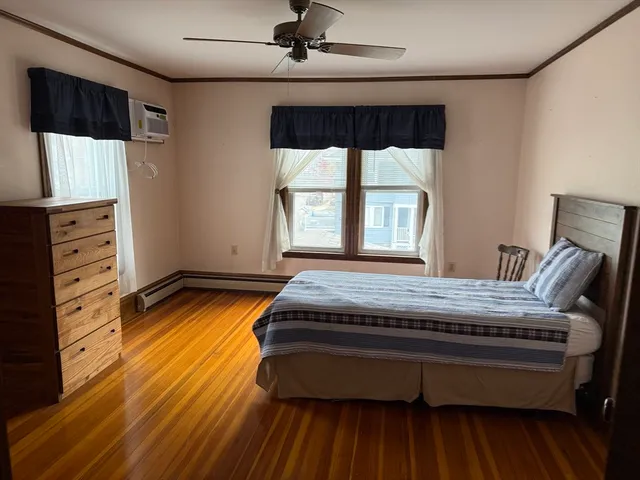 a bedroom with bed and wooden floor