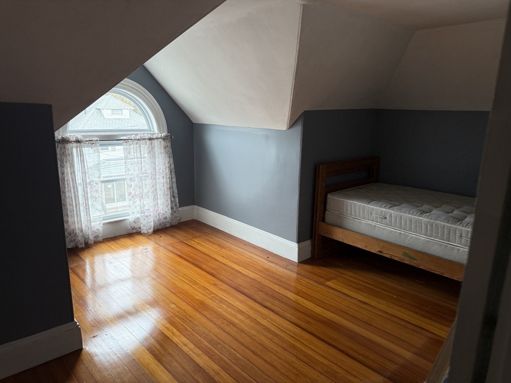 249 Lowell Street Waltham, MA 02453 - Photo 24 of 29 a bedroom with wooden floor and window