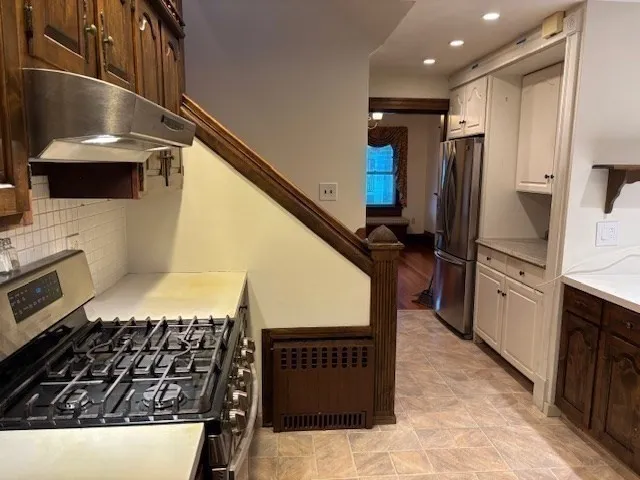 a kitchen with kitchen island granite countertop a stove and a refrigerator