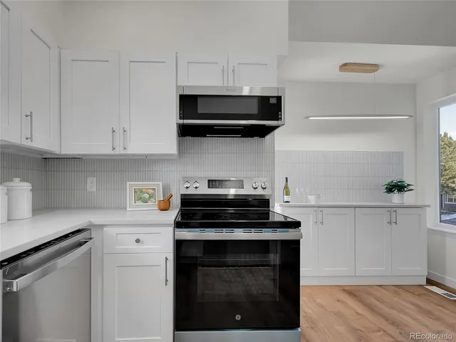 a kitchen with white cabinets and appliances