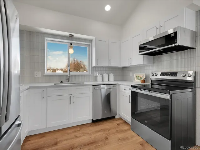 a kitchen with stainless steel appliances granite countertop a sink and a stove top oven