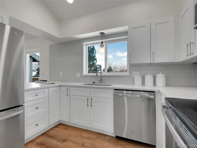 a kitchen with white cabinets and sink