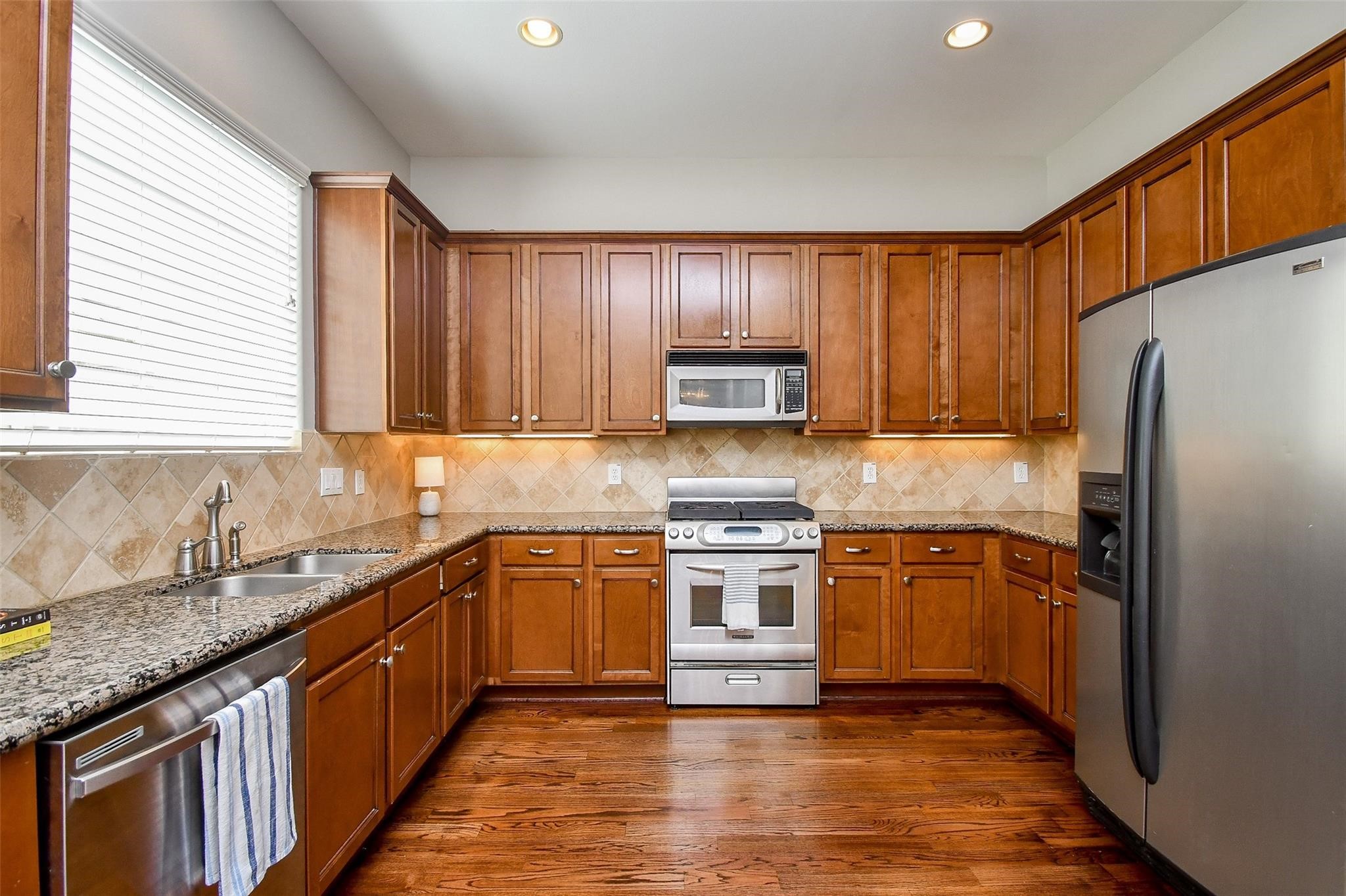 2614 Maxroy Street Houston, TX 77007 - Photo 13 of 32 a kitchen with stainless steel appliances granite countertop wooden cabinets a refrigerator a sink a stove a washer dryer and cabinets