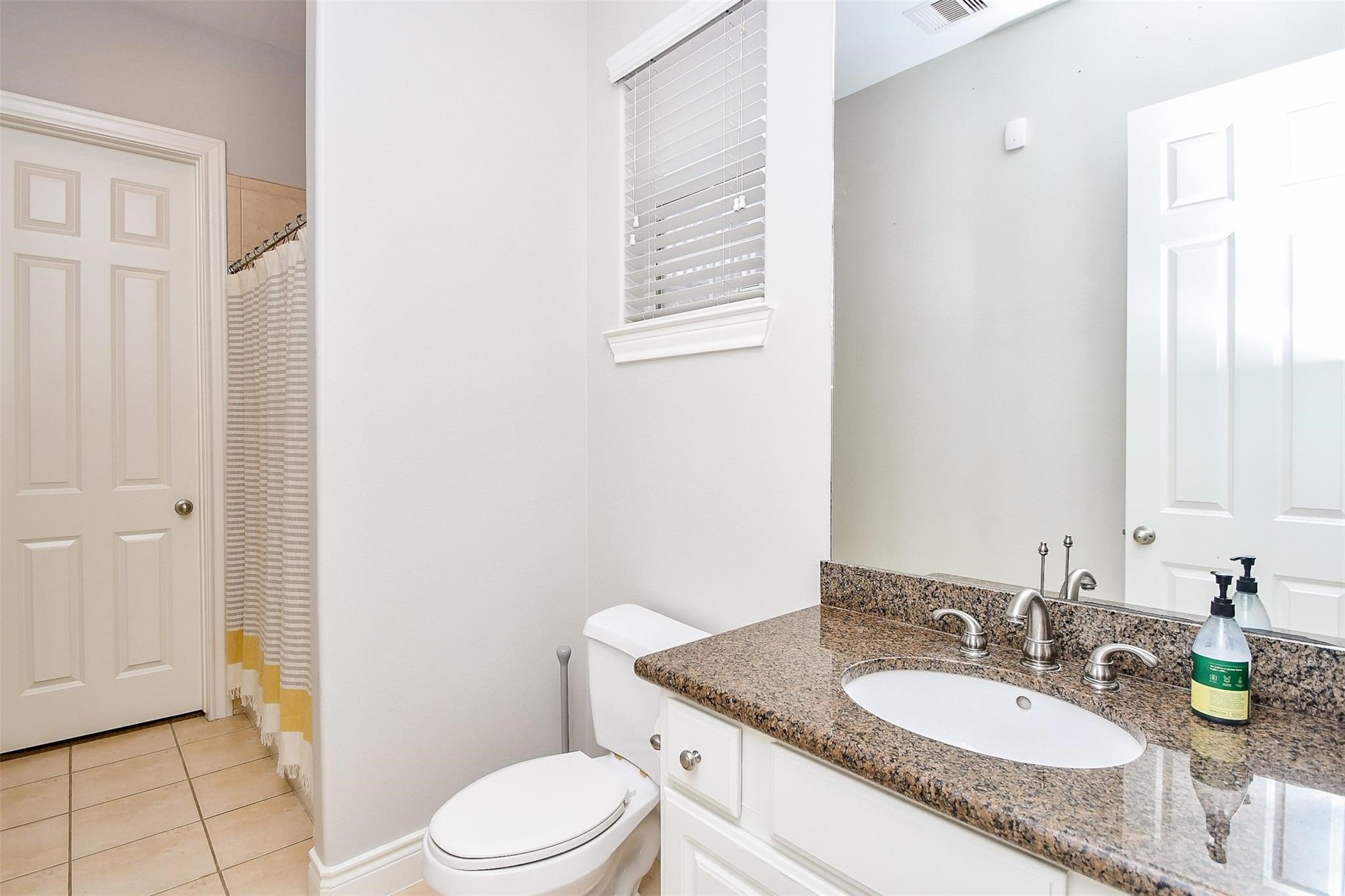 2614 Maxroy Street Houston, TX 77007 - Photo 29 of 32 a bathroom with a granite countertop sink a toilet and a mirror