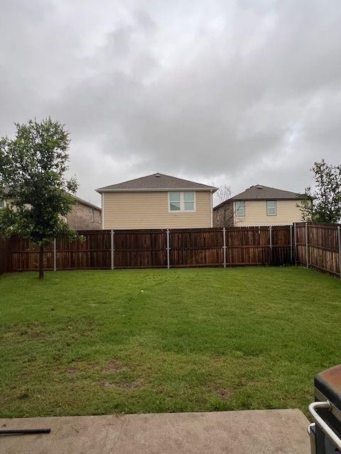 1908 Marquette Road Princeton, TX 75407 - Photo 14 of 14 Expansive backyard featuring a lush green lawn, full wood privacy fencing, and a concrete patio space