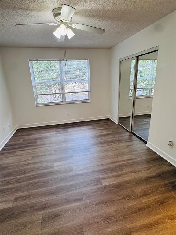 12113 Southwest 2nd Street Pembroke Pines, FL 33025 - Photo 11 of 18 an empty room with wooden floor chandelier fan and windows