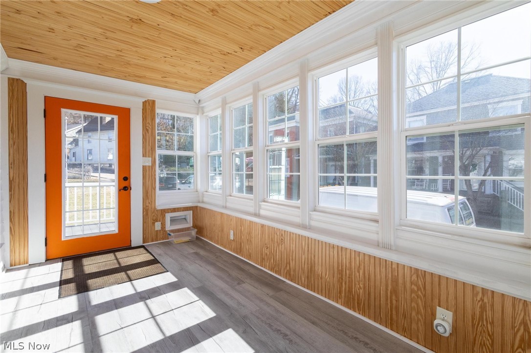 165 9th Street Wellsburg, WV 26070 - Photo 8 of 37 Unfurnished sunroom featuring plenty of natural light, wood finished floors, wood ceiling, wood walls, and ornamental molding
