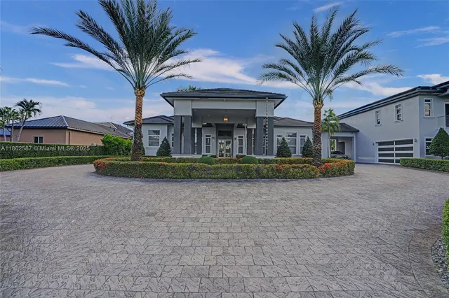 front view of a house with a big yard and palm trees