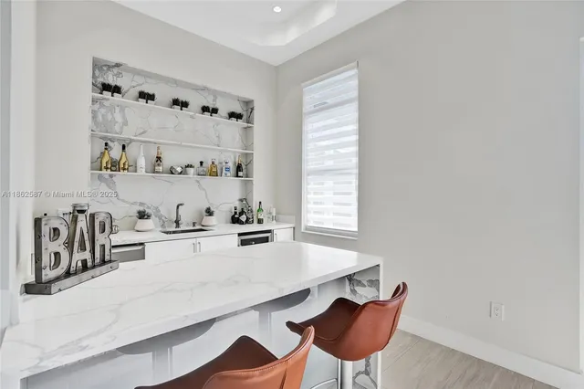 a kitchen with stainless steel appliances a table and chairs in it