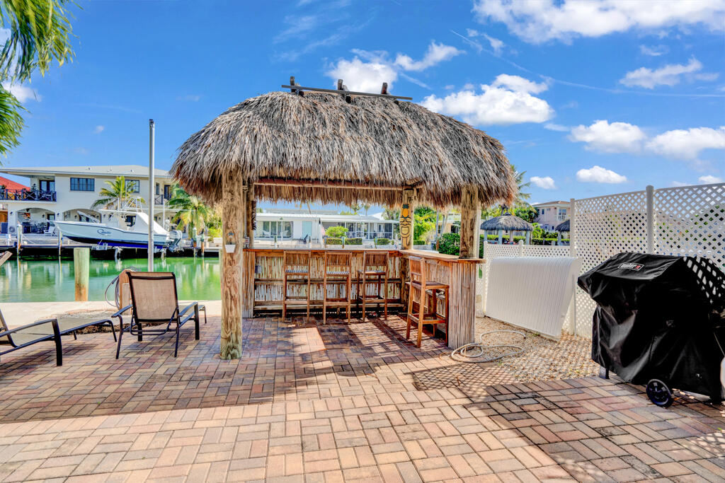 270 9th Street Key Colony Beach, FL 33051 - Photo 1 of 37 a view of a patio with a table and chairs under an umbrella