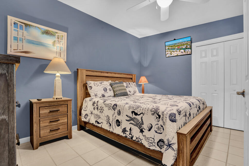 270 9th Street Key Colony Beach, FL 33051 - Photo 13 of 37 a bedroom with a bed and a lamp on dresser