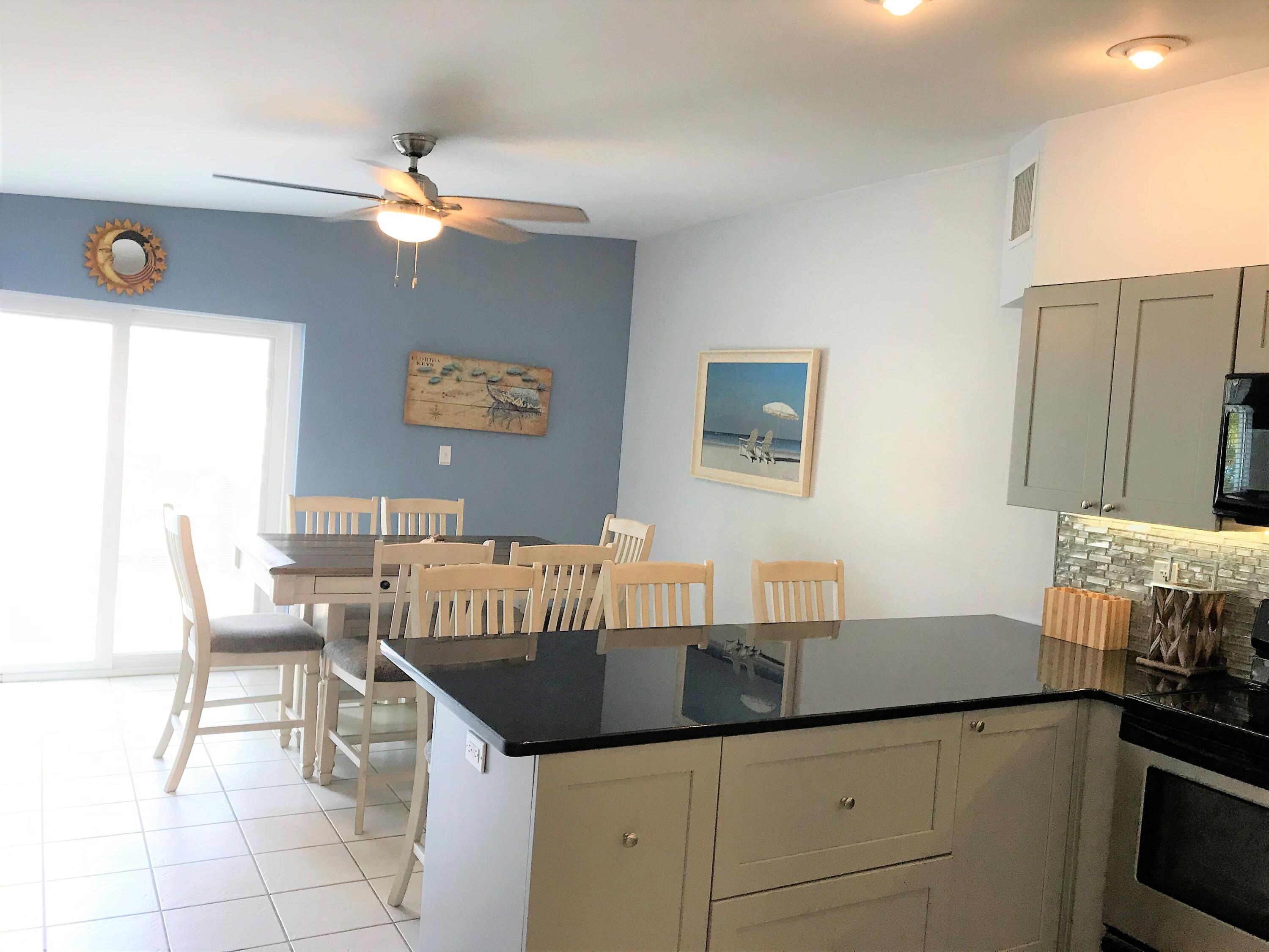 270 9th Street Key Colony Beach, FL 33051 - Photo 6 of 37 a kitchen with a table chairs and white cabinets