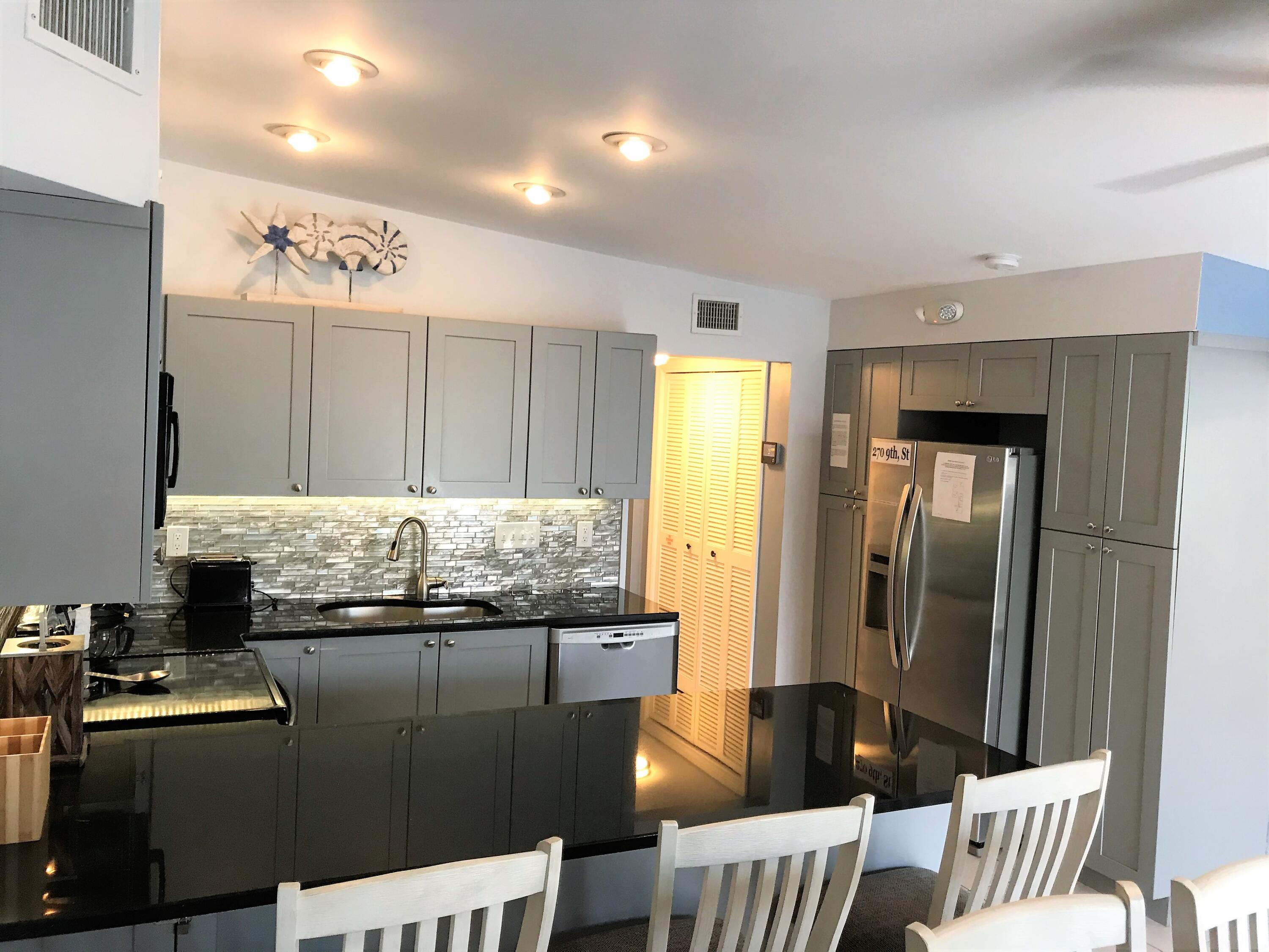 270 9th Street Key Colony Beach, FL 33051 - Photo 7 of 37 a kitchen with stainless steel appliances granite countertop a sink and cabinets