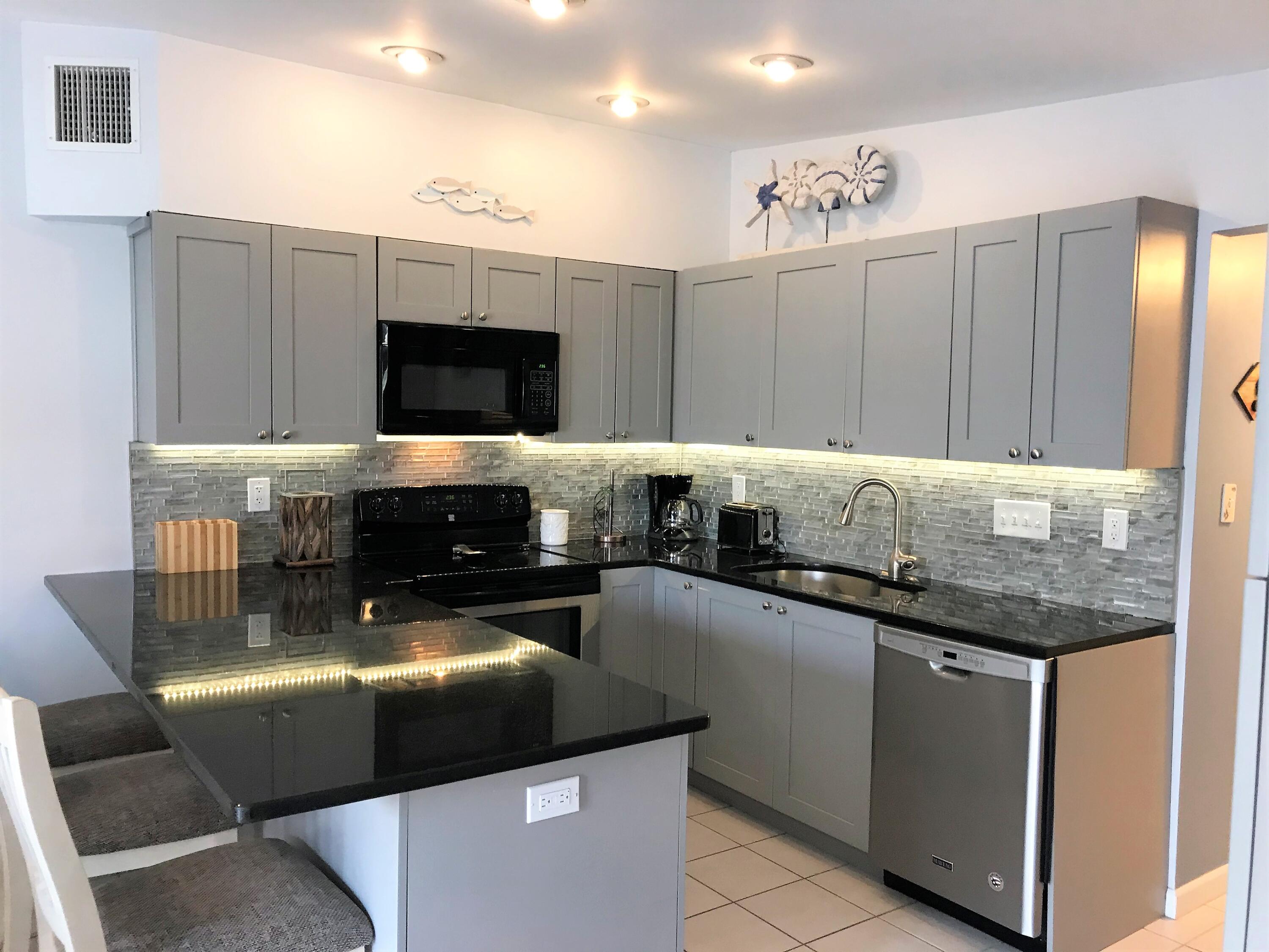 270 9th Street Key Colony Beach, FL 33051 - Photo 8 of 37 a kitchen with granite countertop a stove and cabinets