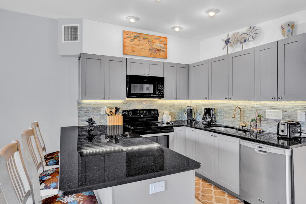 270 9th Street Key Colony Beach, FL 33051 - Photo 9 of 37 a kitchen with granite countertop a stove top oven a sink a counter space and cabinets