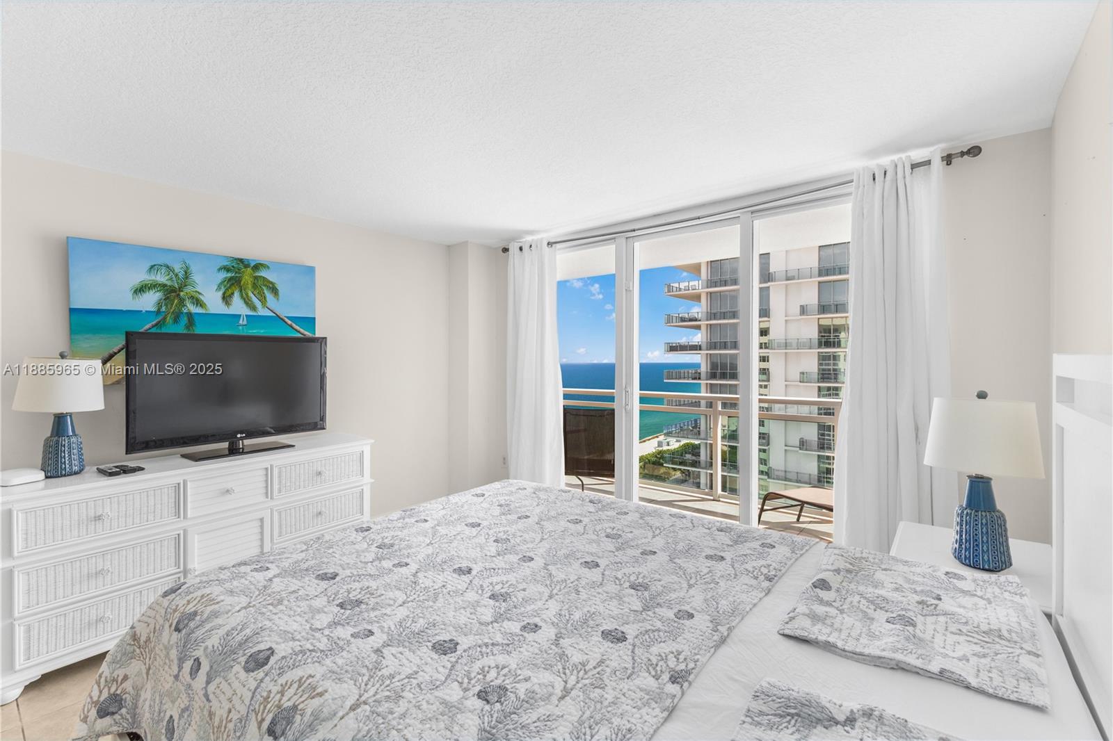 6917 Collins Avenue, Unit 1505 Miami Beach, FL 33141 - Photo 17 of 53 a bedroom with a flat screen tv and a mountain view