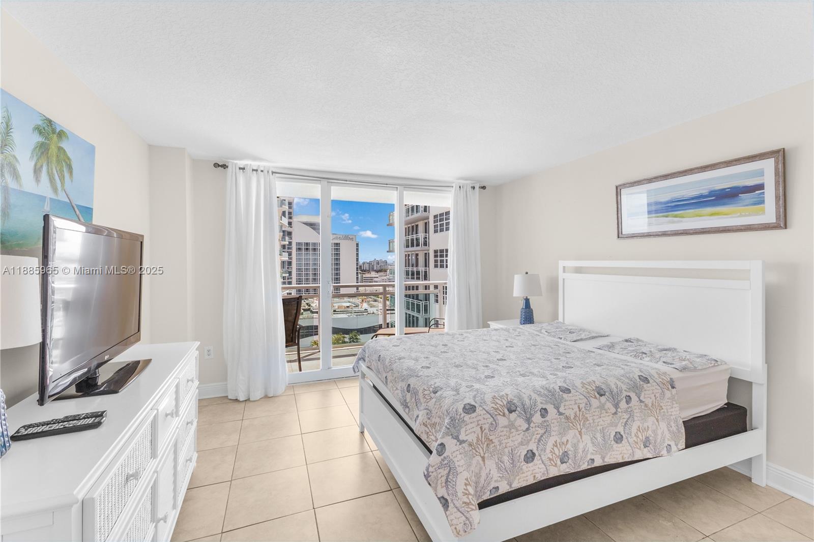 6917 Collins Avenue, Unit 1505 Miami Beach, FL 33141 - Photo 19 of 53 a bedroom with a bed and a flat screen tv