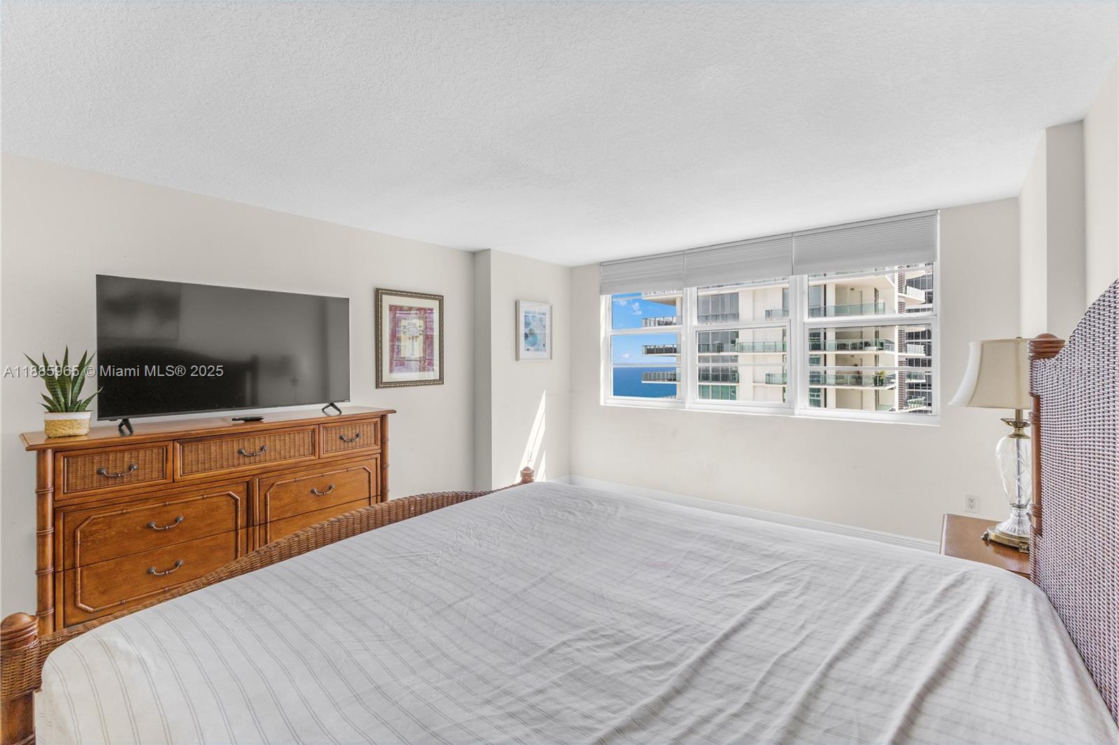 6917 Collins Avenue, Unit 1505 Miami Beach, FL 33141 - Photo 23 of 53 a bedroom with a large bed and a flat screen tv