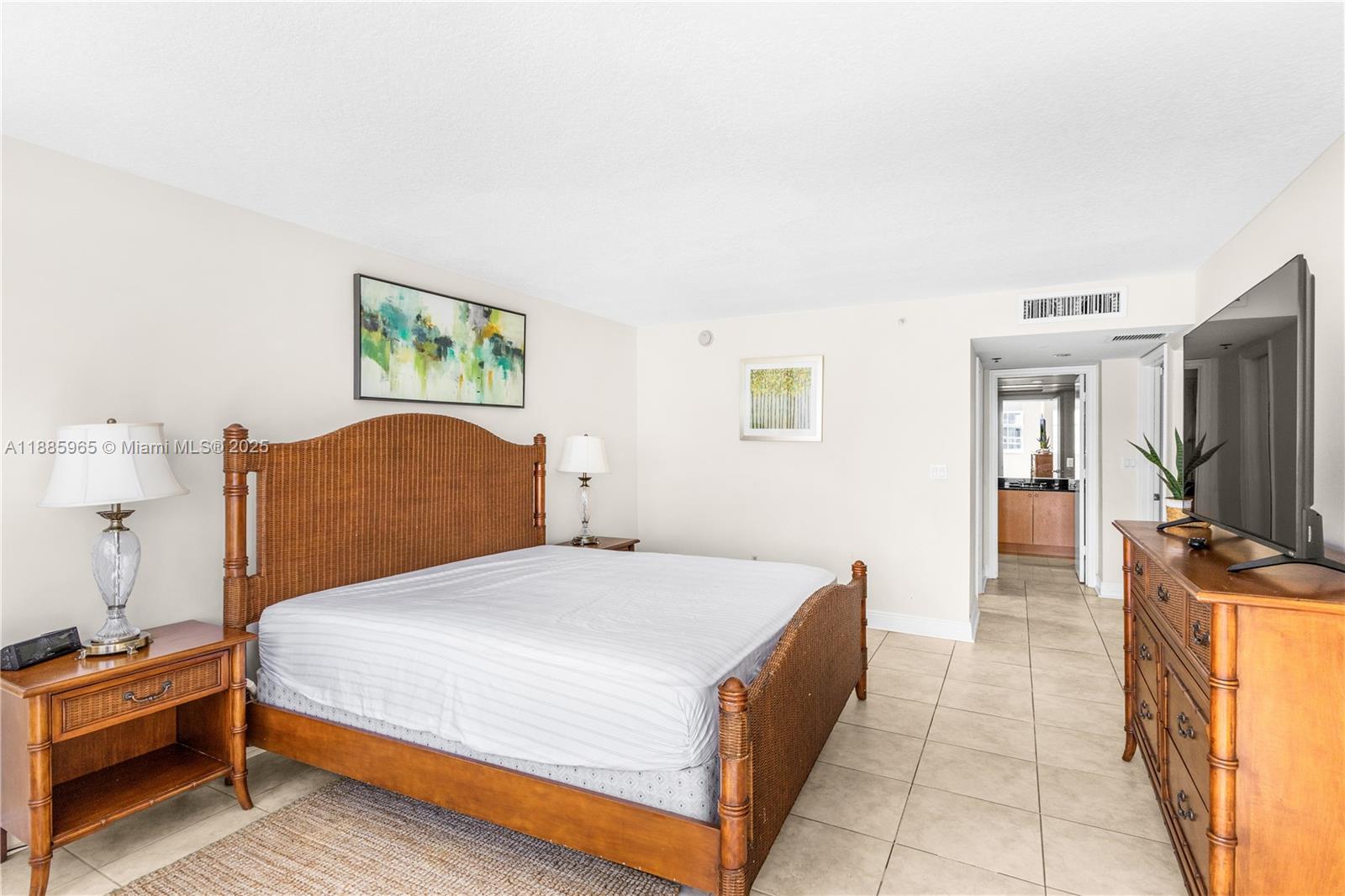 6917 Collins Avenue, Unit 1505 Miami Beach, FL 33141 - Photo 24 of 53 a bedroom with a bed and a flat screen tv