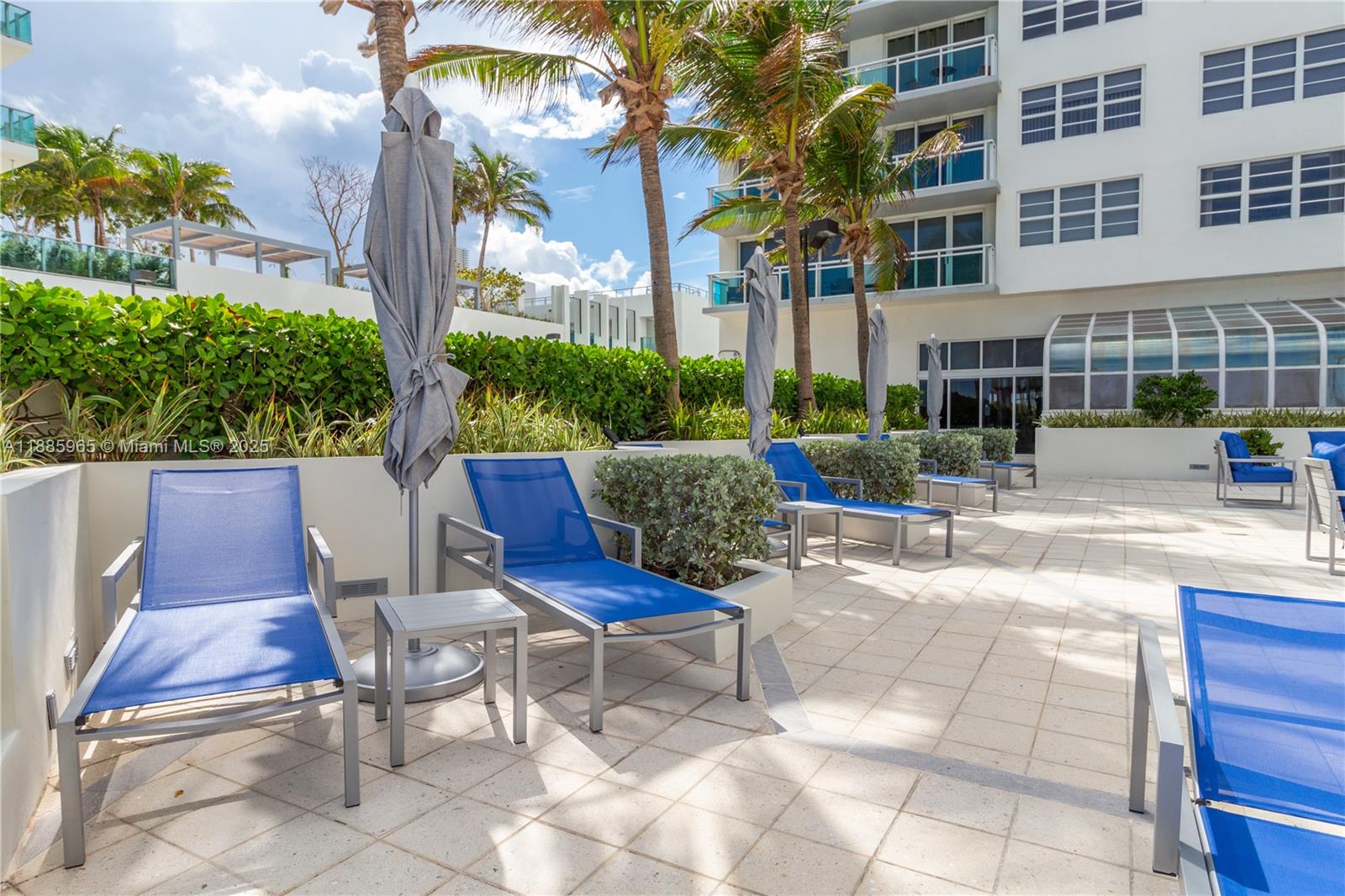 6917 Collins Avenue, Unit 1505 Miami Beach, FL 33141 - Photo 50 of 53 a view of a patio with couches table and chairs and potted plants
