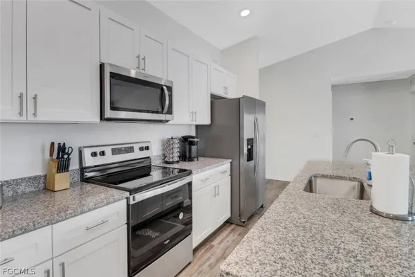 a kitchen with a refrigerator stove and white cabinets