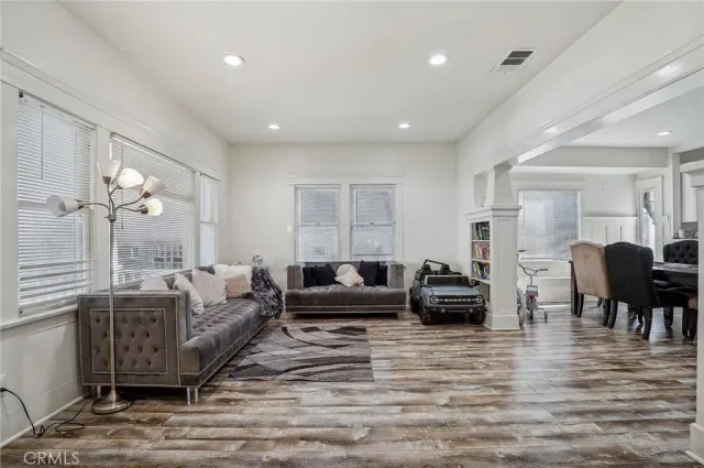 a living room with furniture a dining table a lamp and a chandelier