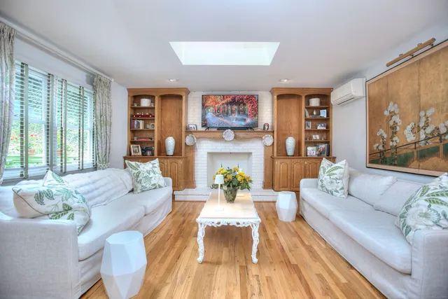 a living room with fireplace furniture and a large window