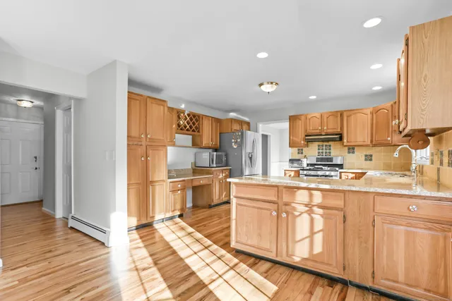 a kitchen with stainless steel appliances granite countertop a refrigerator and a stove top oven