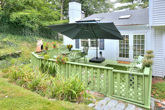 a view of a chair and tables under an umbrella