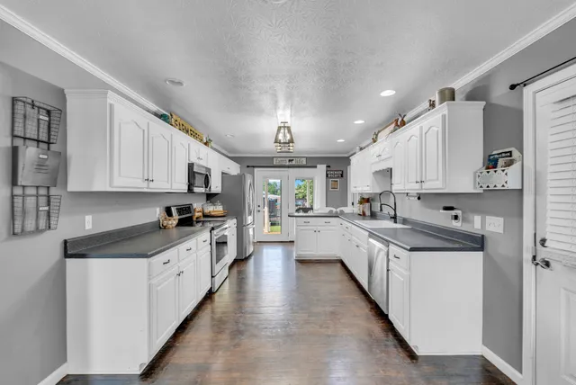 a large kitchen with stainless steel appliances lots of counter space and wooden floor