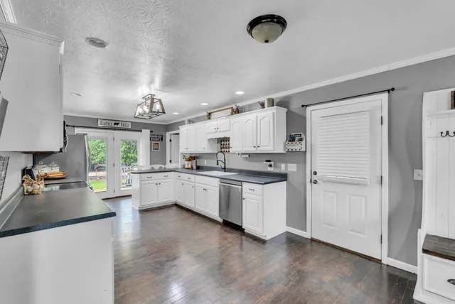 a large white kitchen with cabinets a sink and appliances