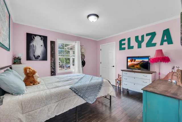 a bedroom with furniture and a flat screen tv