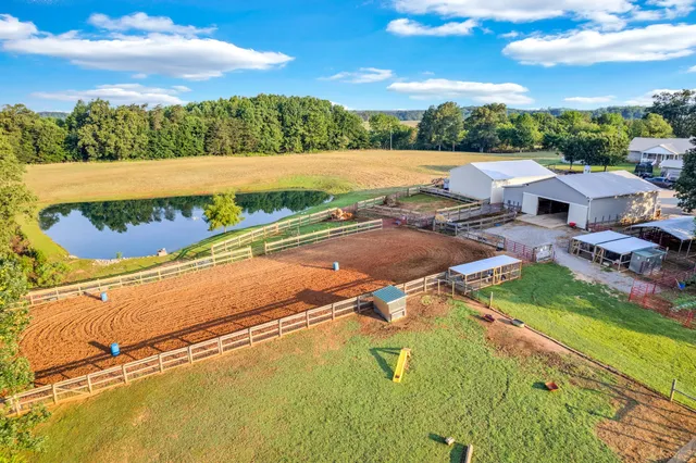 an aerial view of a house with a garden and lake view