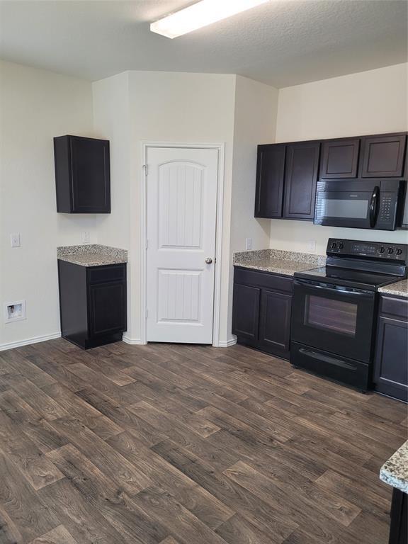 14917 Gypsum Mill Road Manor, TX 78653 - Photo 10 of 28 A well-appointed kitchen features dark wood cabinetry and contrasting light granite countertops.
